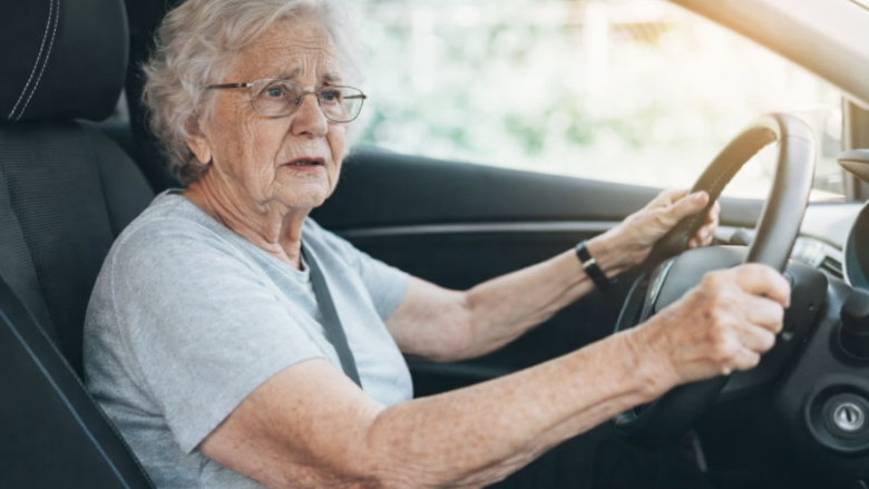„Ältere Frau fährt Auto und schaut konzentriert auf die Straße Thema Autofahren im Alter und Pflegegrad.“